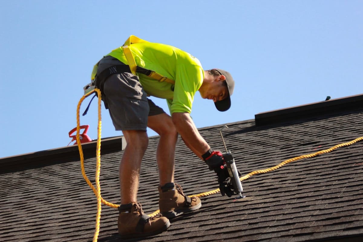 A roofer installing shingles on a residential roof — the kind of project an AllContraX estimate covers